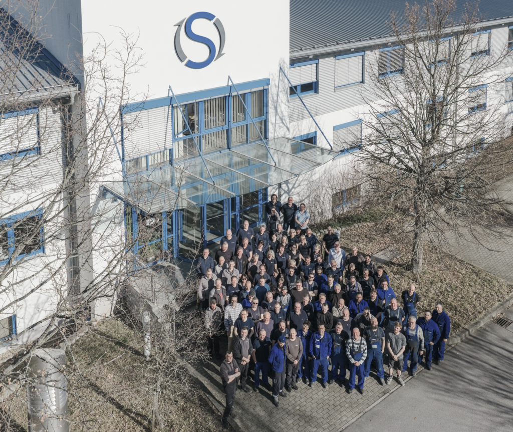 Mitarbeitende von SANTENBERG vor dem Firmengebäude – kompetentes Team für Sondermaschinenbau und präzise Metallbearbeitung.