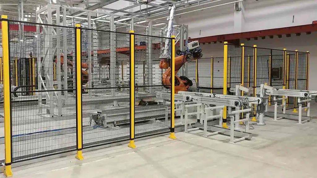 Schutzgitter-Einhausung einer Roboterzelle mit Förderbändern – SANTENBERG Sicherheitstechnik