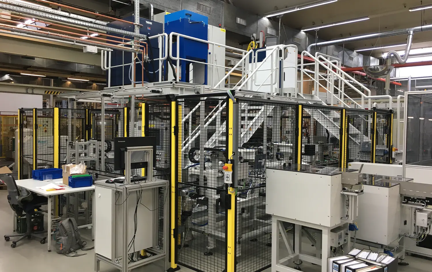 Automatisierte Fertigungsanlage mit Schutzgitter und Bedienstation – SANTENBERG Sondermaschinenbau